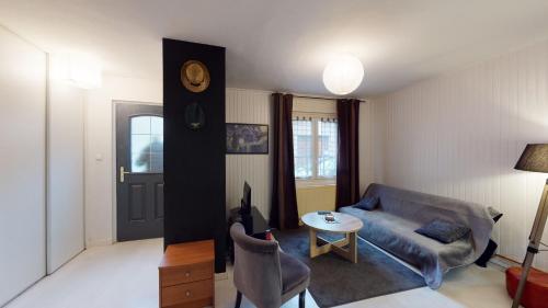 ein Wohnzimmer mit einem Sofa und einem Tisch in der Unterkunft L'Episcopale - Maison 2 chambres in Albi