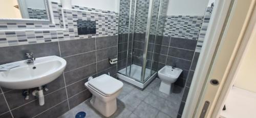 une salle de bain avec un lavabo, des toilettes et une douche dans l'établissement Corso 51 stay Napoli, à Naples