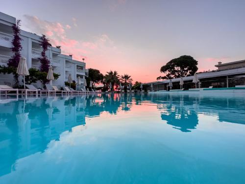 une grande piscine avec un coucher de soleil en arrière-plan dans l'établissement Marathon Beach Resort, à Nea Makri