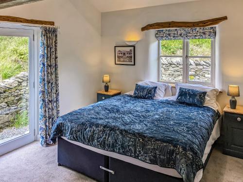 1 dormitorio con 1 cama y 2 ventanas en Saul Hill, en Lake District National Park