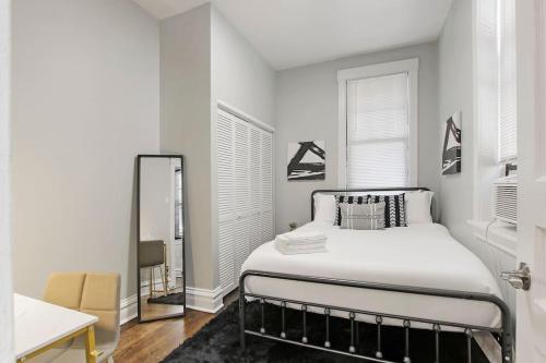 Habitación blanca con cama y espejo en City Charm 2BR Apartment - Clark 4, en Chicago