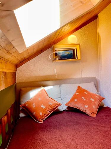 Cette petite chambre comprend un canapé et deux oreillers. dans l'établissement Appartement 6 personnes les Contamines Montjoie, aux Contamines-Montjoie
