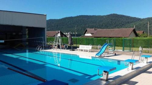 a swimming pool with a slide and a playground at La Clémentine in Vagney