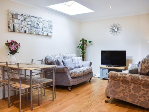 a living room with a couch and a table and a tv at Teddys Cottage - Uk44685 in Burnopfield