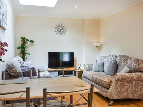 a living room with a couch and a tv at Teddys Cottage - Uk44685 in Burnopfield