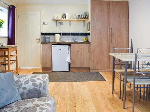 uma cozinha e sala de estar com um sofá e uma mesa em Teddys Cottage - Uk44685 em Burnopfield