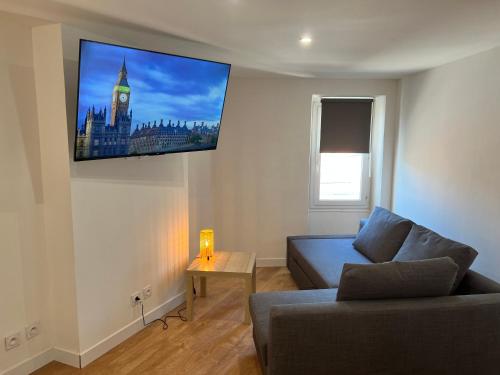 un salon avec un canapé et une télévision au mur dans l'établissement Studio Neuf CentreVille Climatisé #14, à Toulon