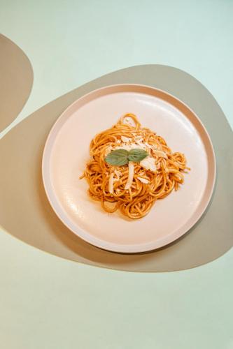 a plate of spaghetti with a green leaf on it at Casa Natu Ilhabela Portinho in Ilhabela