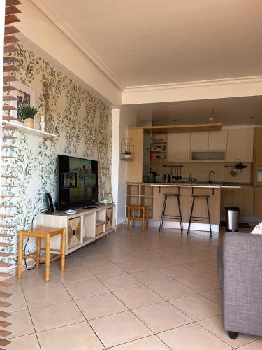 a living room with a tv and a kitchen at Três palmeiras with pool in Portimão