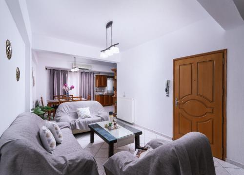 Sala de estar con 2 sofás y mesa en Katerina Family Apartments, en Moírai