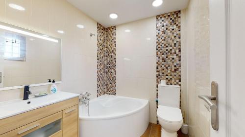 ein Badezimmer mit Badewanne, Toilette und Waschbecken in der Unterkunft Casa de Lago - A Murcia Holiday Rentals Property in Playa de los Nietos