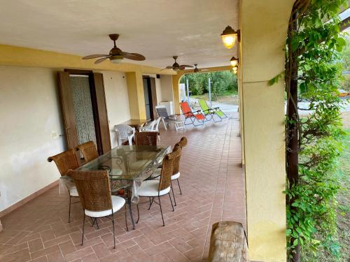 une terrasse couverte avec une table et des chaises. dans l'établissement Villa Pientime - natura e mare, à Formia