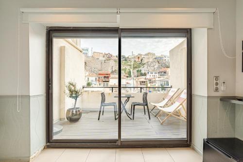 cocina con balcón con mesa y sillas en Les Cabanons de Fonfon en Marsella