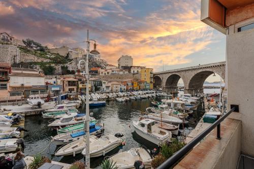 a group of boats docked in a marina with a bridge at Les Cabanons de Fonfon in Marseille
