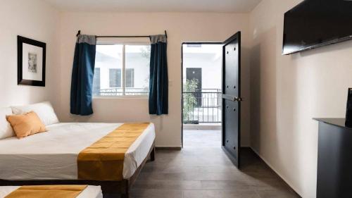 - une chambre avec un lit et une porte donnant sur un balcon dans l'établissement Hotel Posada San Esteban, à San Luis Potosí