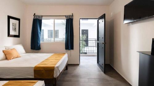 1 dormitorio con 1 cama y puerta a un balcón en Hotel Posada San Esteban, en San Luis Potosí