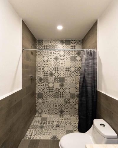 a bathroom with a toilet and a shower at Hotel Posada San Esteban in San Luis Potosí