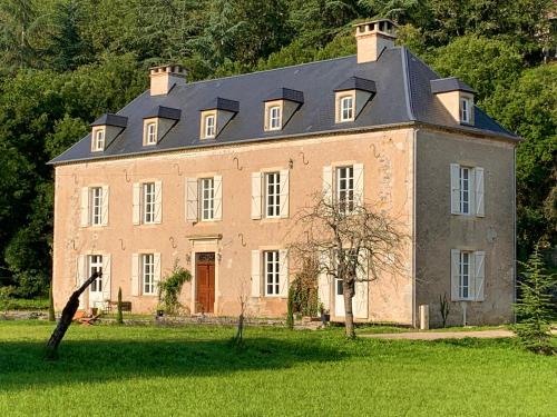 una gran casa de ladrillo con un techo grande en NOUBAR, en Cénevières