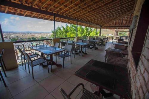 un restaurant avec des tables et des chaises sur un balcon dans l'établissement Gravatá - Flat Fazenda Monte Castelo, à Sairé