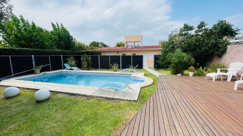 un patio trasero con piscina y una casa en Excelente Casa c/ Pileta Cerca del Centro en Villa Carlos Paz