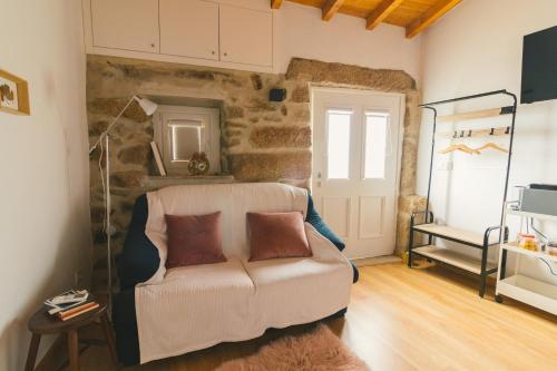a living room with a couch and a stone wall at CHALÉ in Alijó