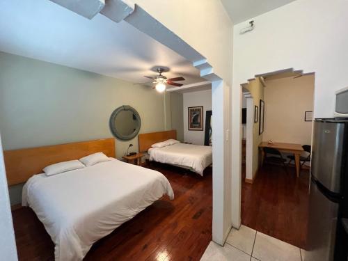 マイアミビーチにあるシャーブルック オール スイーツ ホテルのベッド2台と鏡が備わるホテルルームです。