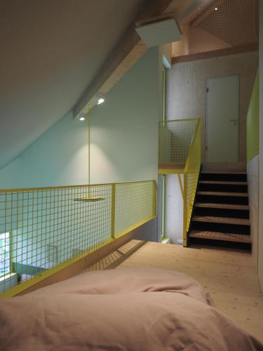 a bedroom with a bed and a staircase in the background at Bleibe Menzenschwand in St. Blasien