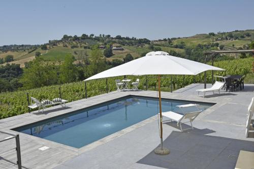 una piscina con sombrilla, mesa y sillas en Agriturismo Casale Contessa, en Montebuono