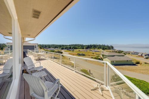 a balcony with white chairs and a view of the ocean at Stunning Home in Coupeville with Deck and Beach Access in Coupeville