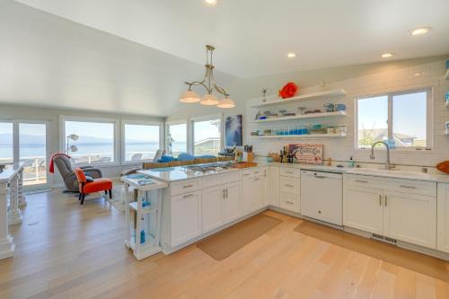 a kitchen with white cabinets and windows and a table at Stunning Home in Coupeville with Deck and Beach Access in Coupeville