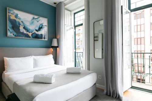 sypialnia z dużym łóżkiem i dużym oknem w obiekcie Lisboa 85 Suites & Apartments by RIDAN Hotels w Lizbonie