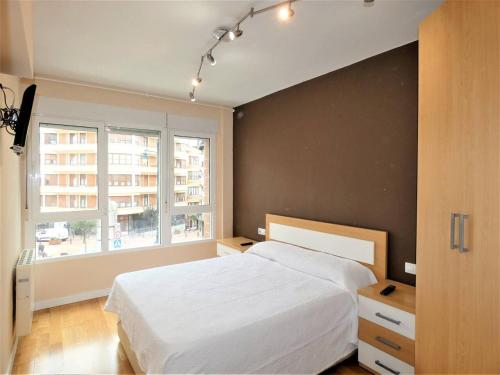 a bedroom with a white bed and a window at apartamento gran bilbao II in Barakaldo