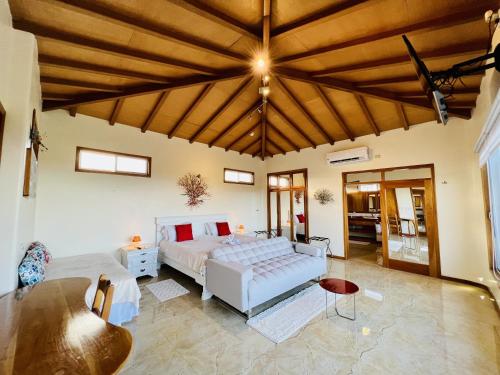 Blue Heron Galápagos Villa في بويرتو أيورا: غرفة نوم كبيرة مع سرير وطاولة