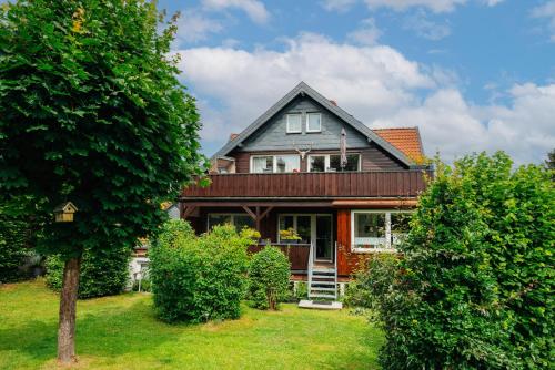 ein Haus mit einer Veranda und einem Garten mit Büschen in der Unterkunft Feriendomizil Tippe in Braunlage