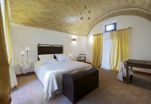 a bedroom with a bed and a table and a television at Torre della Botonta in Castel Ritaldi