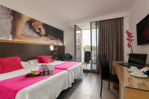 Flash Hotel Benidorm - Recommended Adults Only 4 Sup في بنيدورم: غرفة فندقية بسريرين ولوحة كبيرة على الحائط
