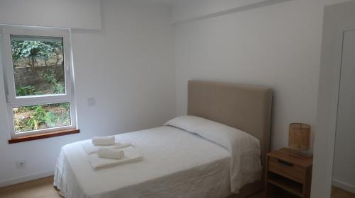 een witte slaapkamer met een bed en 2 ramen bij Apartamento Renovado no Centro da Cidade - Casa4 in Coimbra