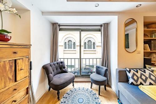 ein Wohnzimmer mit einem Sofa, Stühlen und einem Fenster in der Unterkunft Le petit Crequi- appartement atypique 2 pers- Foch in Lyon