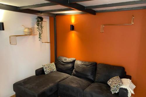 - un salon avec un canapé brun et un mur orange dans l'établissement Charming Apartment with Exposed Beams Ainay District Lyon, à Lyon