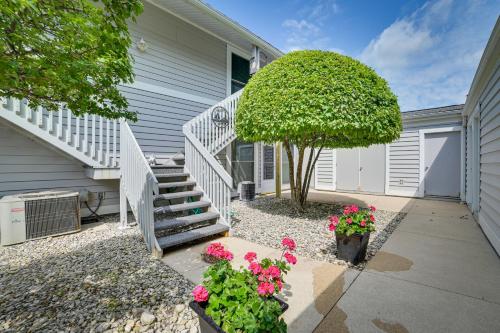 a house with a staircase and a tree and flowers at Luxury Lakefront Boyne City Townhome with Views! in Boyne City