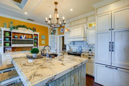 a kitchen with white cabinets and a large island at Waterfront Stuart Home on St Lucie River! in Stuart
