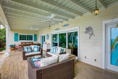a screened in porch with wicker furniture and a ceiling at Waterfront Stuart Home on St Lucie River! in Stuart