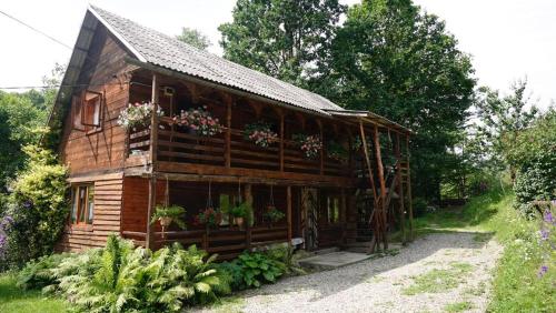 a wooden house with flowers on the side of it at Cabana Victor in Sighetu Marmaţiei