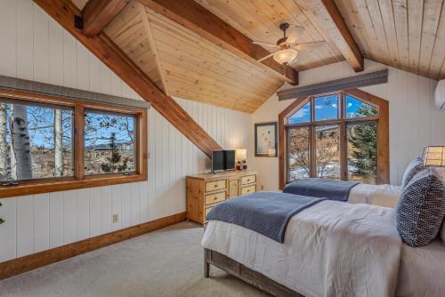 1 dormitorio con 2 camas y ventanas en una cabaña en 1034- Ski In Ski Out Home on the Slopes en Steamboat Springs