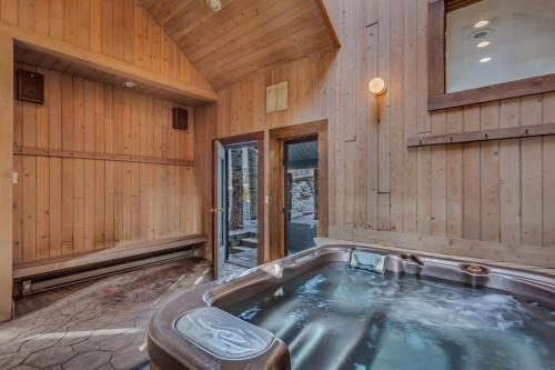 bañera de hidromasaje en una habitación con paredes de madera en 1034- Ski In Ski Out Home on the Slopes en Steamboat Springs
