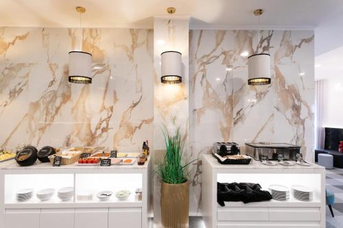 a kitchen with white counters and a marble wall at Lisboa 85 Suites & Apartments by RIDAN Hotels in Lisbon