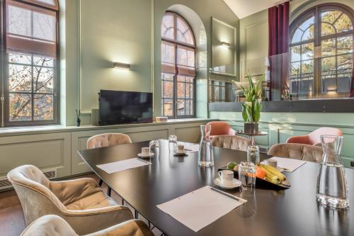 a restaurant with a table and chairs and a tv at Les Suites de l'Ile Barbe in Lyon