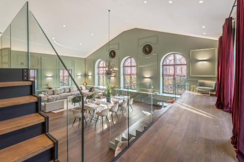 a living room with a staircase and a dining room at Les Suites de l'Ile Barbe in Lyon