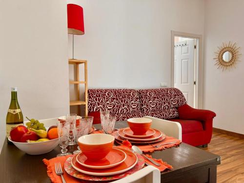a living room with a table and a red couch at Historic Center Cathedral in Málaga