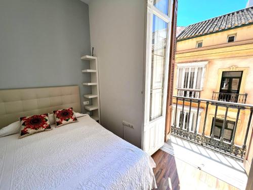 a bedroom with a bed and a large window at Historic Center Cathedral in Málaga